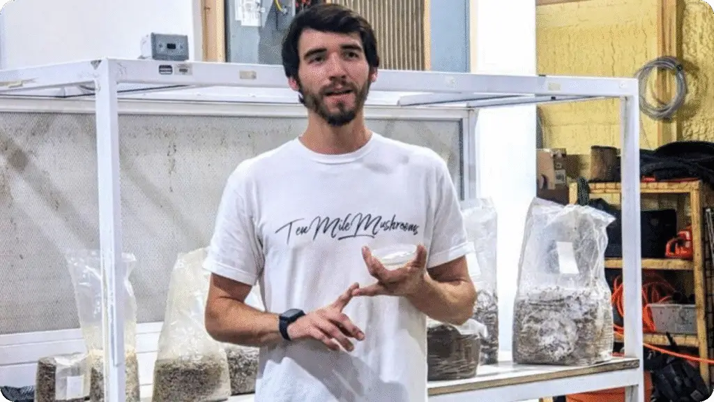 man wearing Ten Mile Mushrooms shirt talking about mushroom grain spawn
